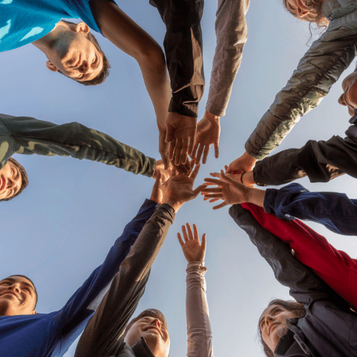 Group of people joining hands together.