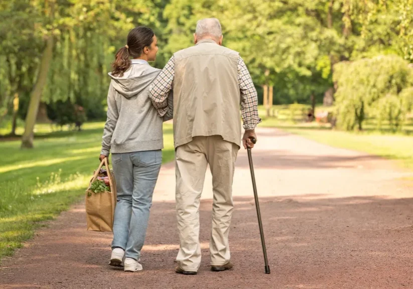 Elderly man and woman walking in park.