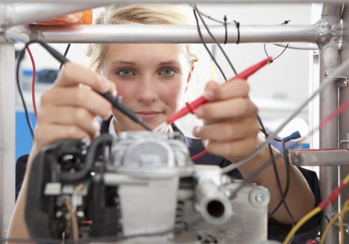 Woman working on engineering project with tools.