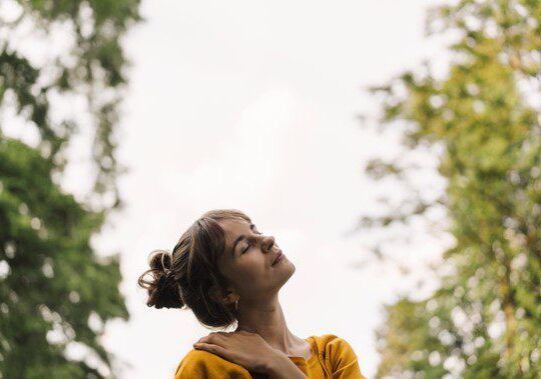 Woman enjoying nature with closed eyes.